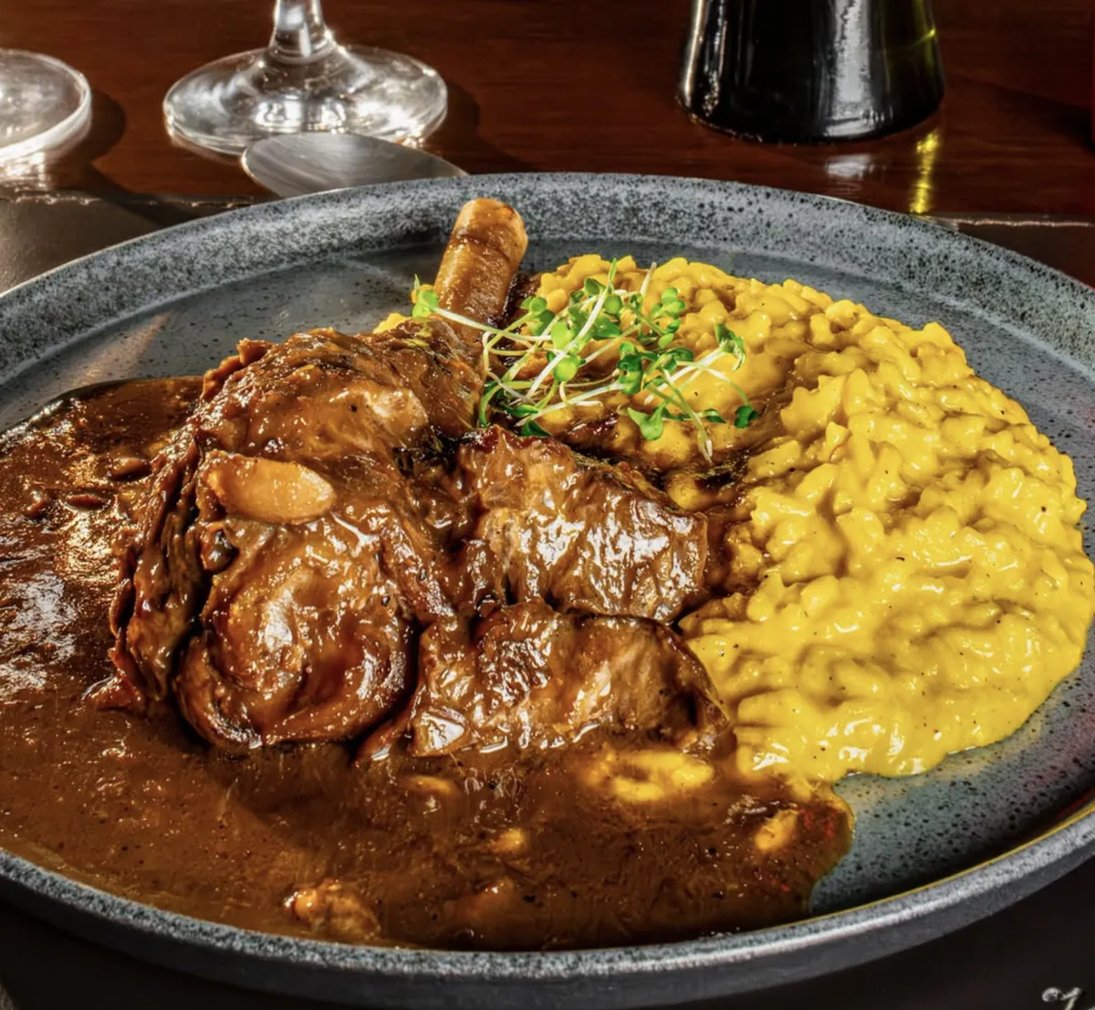 Carne braseada ao molho com risoto de açafrão, do cardápio à la carte