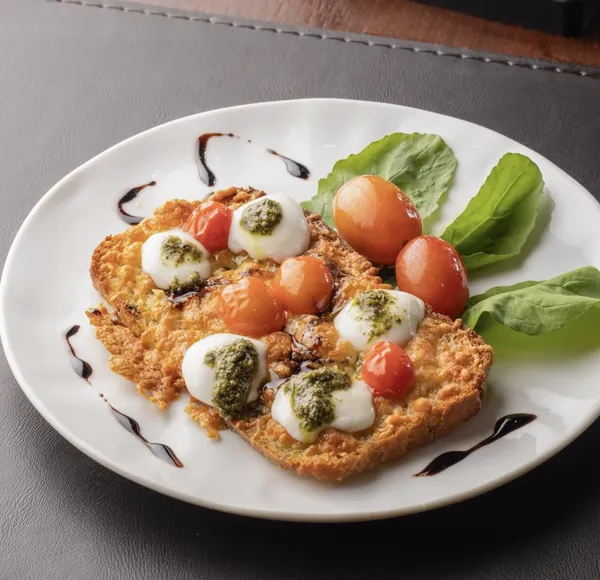 Bruschetta caprese com tomate confit, mussarela de búfala e pesto
