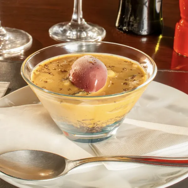 Sobremesa cremosa em taça com gelato de frutas vermelhas